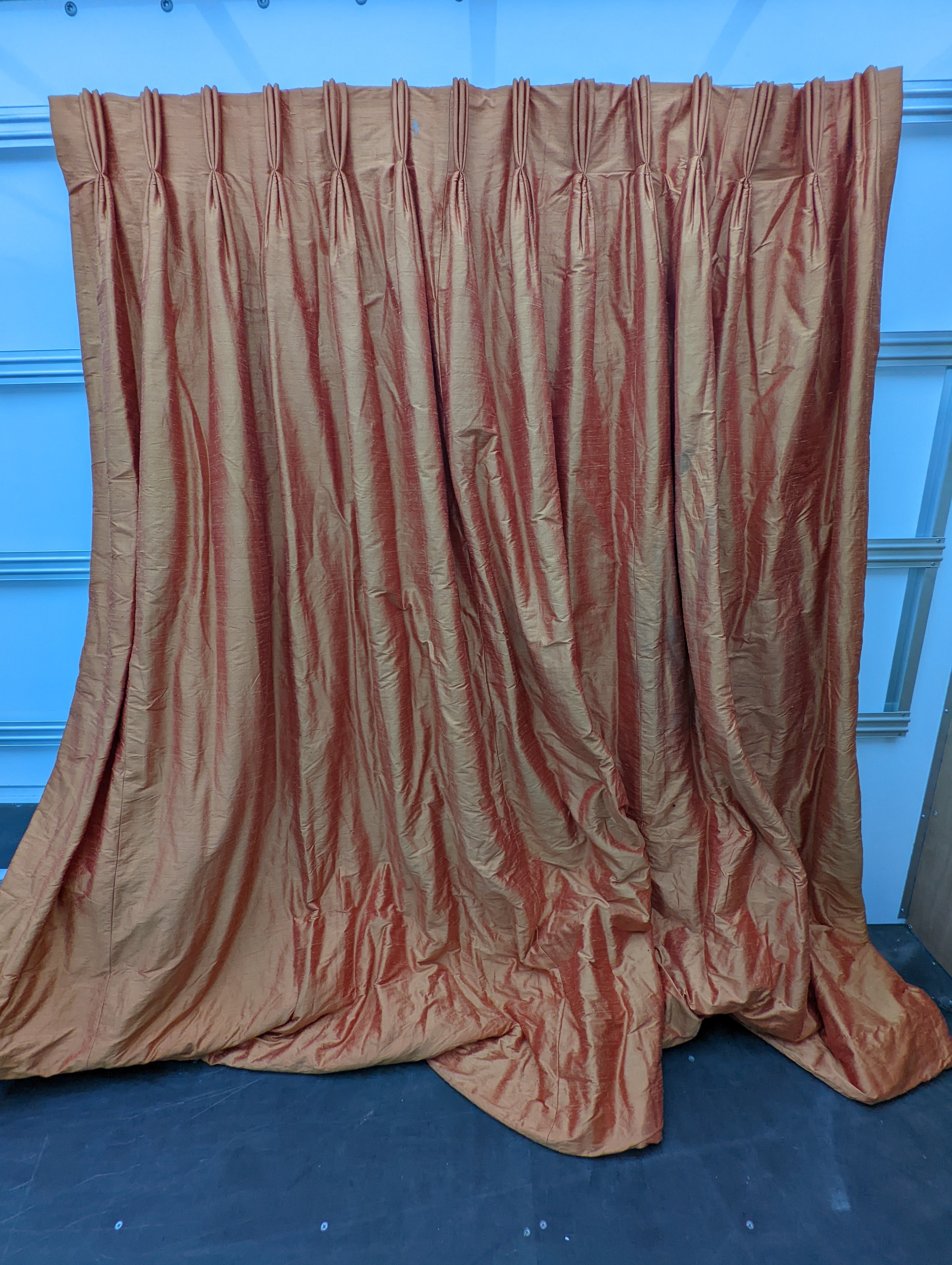 A pair of orange lined curtains. Approximate measurements: Width of top 180cm, Width of bottom 320cm Length 250cm